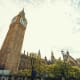 Big Ben clock tower and Houses of Parliament with green trees in London under cloudy sky